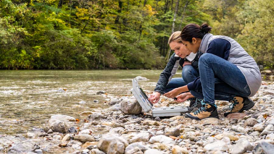 Two Ecologists Performing A River Water Study Using A Tablet How Consultants Use Fulcrum To Prove Environmental Impact Blog