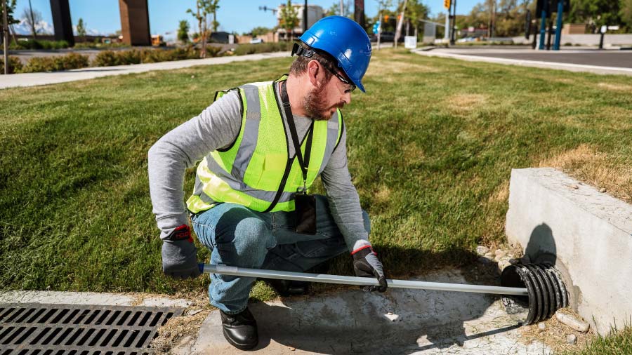 Water Utility Worker Inspecting Storm Drain Fixing The Gap Between Your Water Audit And Field Data Feature (1)